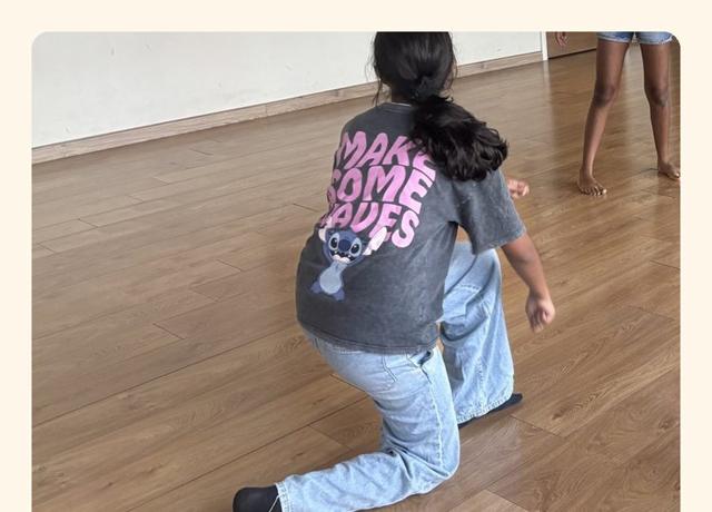A child holding a frozen pose in the studio