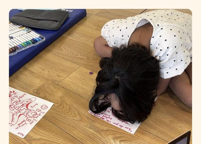 A child drawing ideas on paper, seen from above